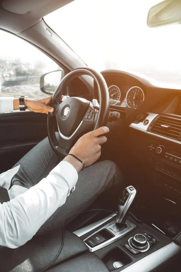 Man sitting in a clean detailed car in a white shirt