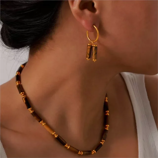 woman with gold plated tiger eye earrings and necklace